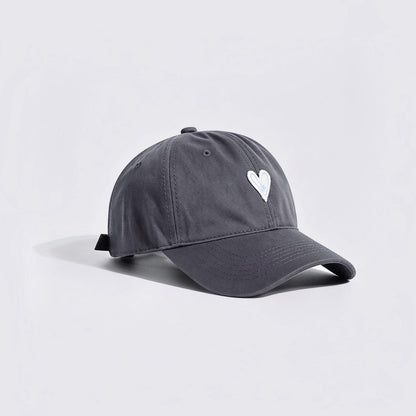 Side view of a charcoal grey baseball hat featuring white heart embroidery.
