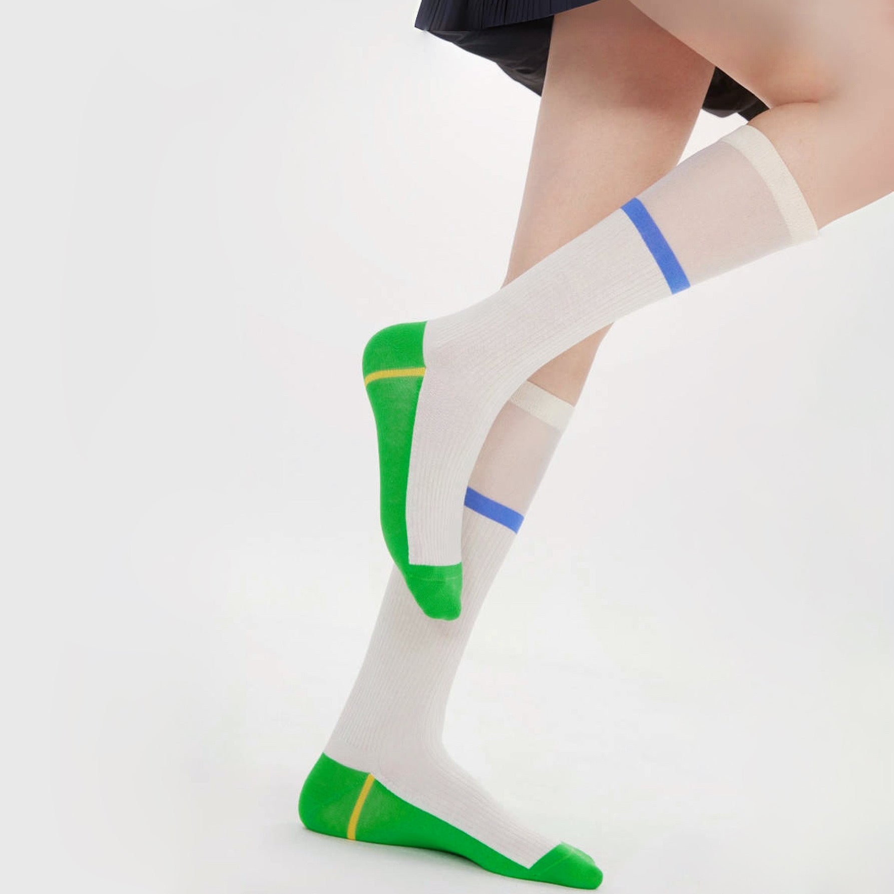 Model wearing a pair of green knee-high patchwork socks, great for casual wear and light workouts.