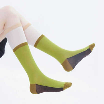 Model wearing a pair of olive green cotton knee-high socks, ideal for everyday outfits and sneakers.
