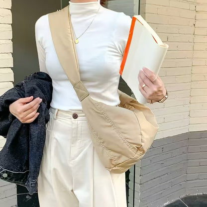 Khaki padded nylon crescent bag in a minimalist urban look, featuring a wide shoulder strap for comfort.
