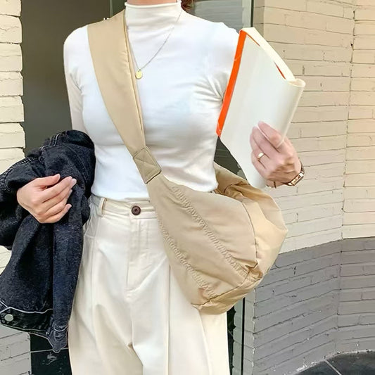 Khaki padded nylon crescent bag in a minimalist urban look, featuring a wide shoulder strap for comfort.