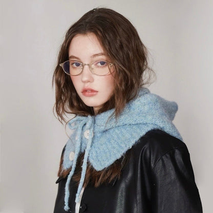 Side profile of the blue knitted balaclava hat styled with a black leather jacket for a chic winter look.