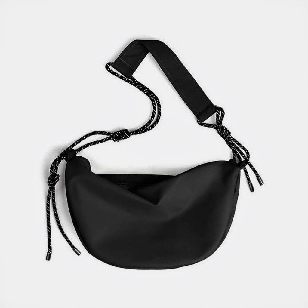 Front view of black knotted nylon crescent sling bag, highlighting the high-density ripstop material and zip-top.