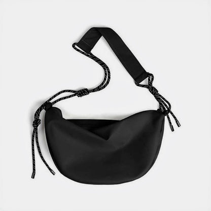 Front view of black knotted nylon crescent sling bag, highlighting the high-density ripstop material and zip-top.