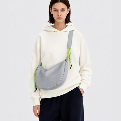 Model styling a light grey knotted nylon sling bag, minimalist everyday cool accessory for urban nomads.