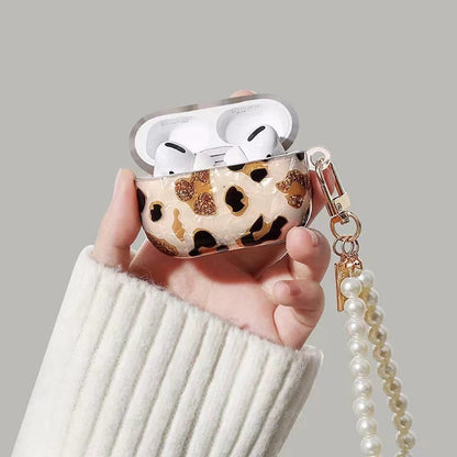 Model Hands holding a Leopard Print AirPods Case Cover with pearl string, great for daily use and protection.