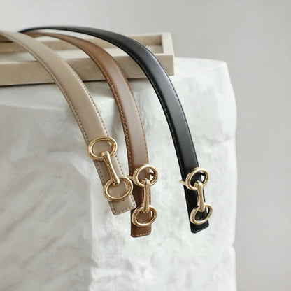 Close-up of three Linked Loop Belts in brown, black, and khaki, showing the gold-tone buckle detail .