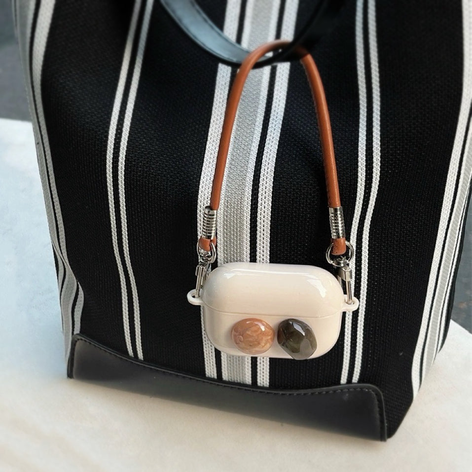 Close-up of Maillard Color Stone AirPods Case Cover hanging on a bag, ideal for gifting and everyday use.