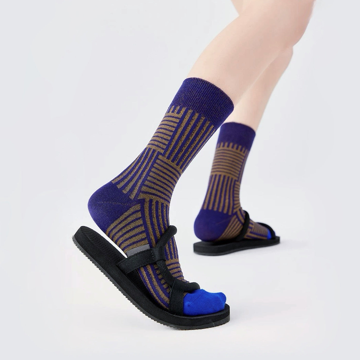 Model wearing a pair of blue matrix striped socks, great for casual wear and light workouts.