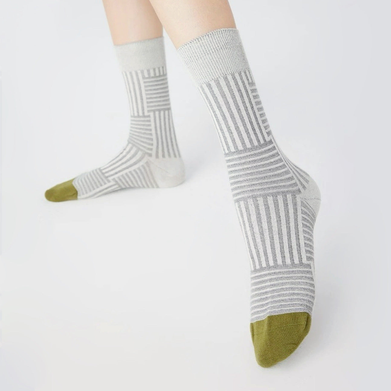 Model wearing a pair of Matrix Stripe Socks in gray, easy to pack for travel and errands.
