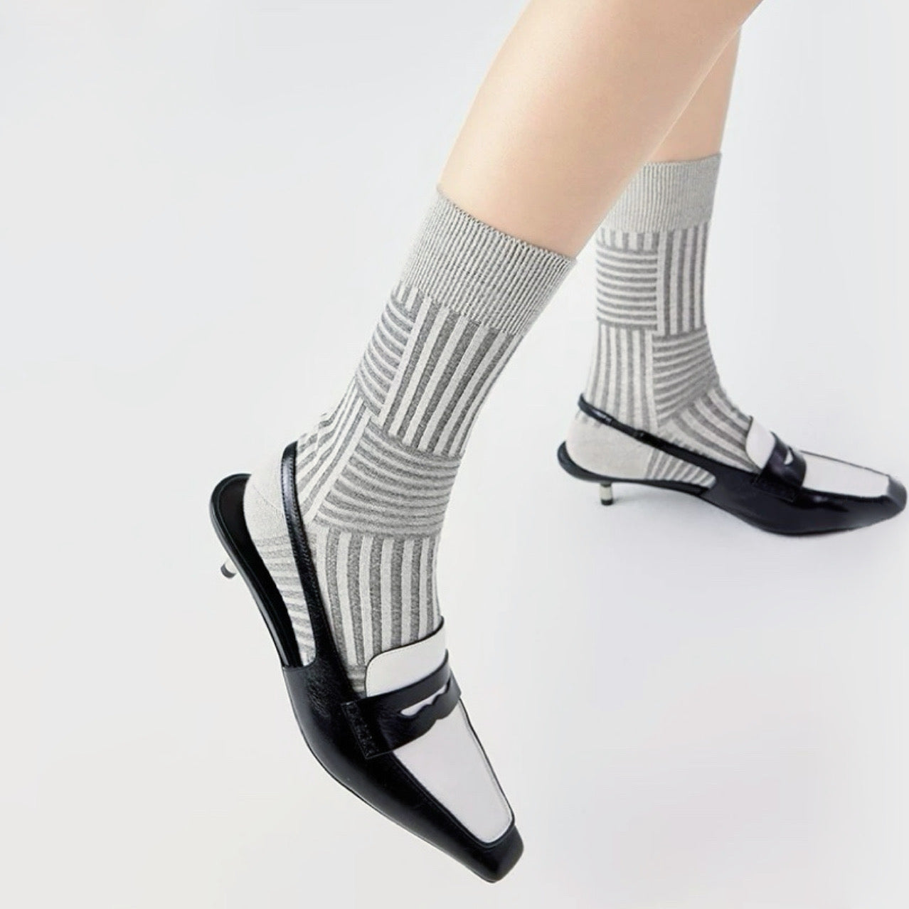 Model wearing a pair of gray matrix striped socks, ideal for everyday outfits and sneakers.