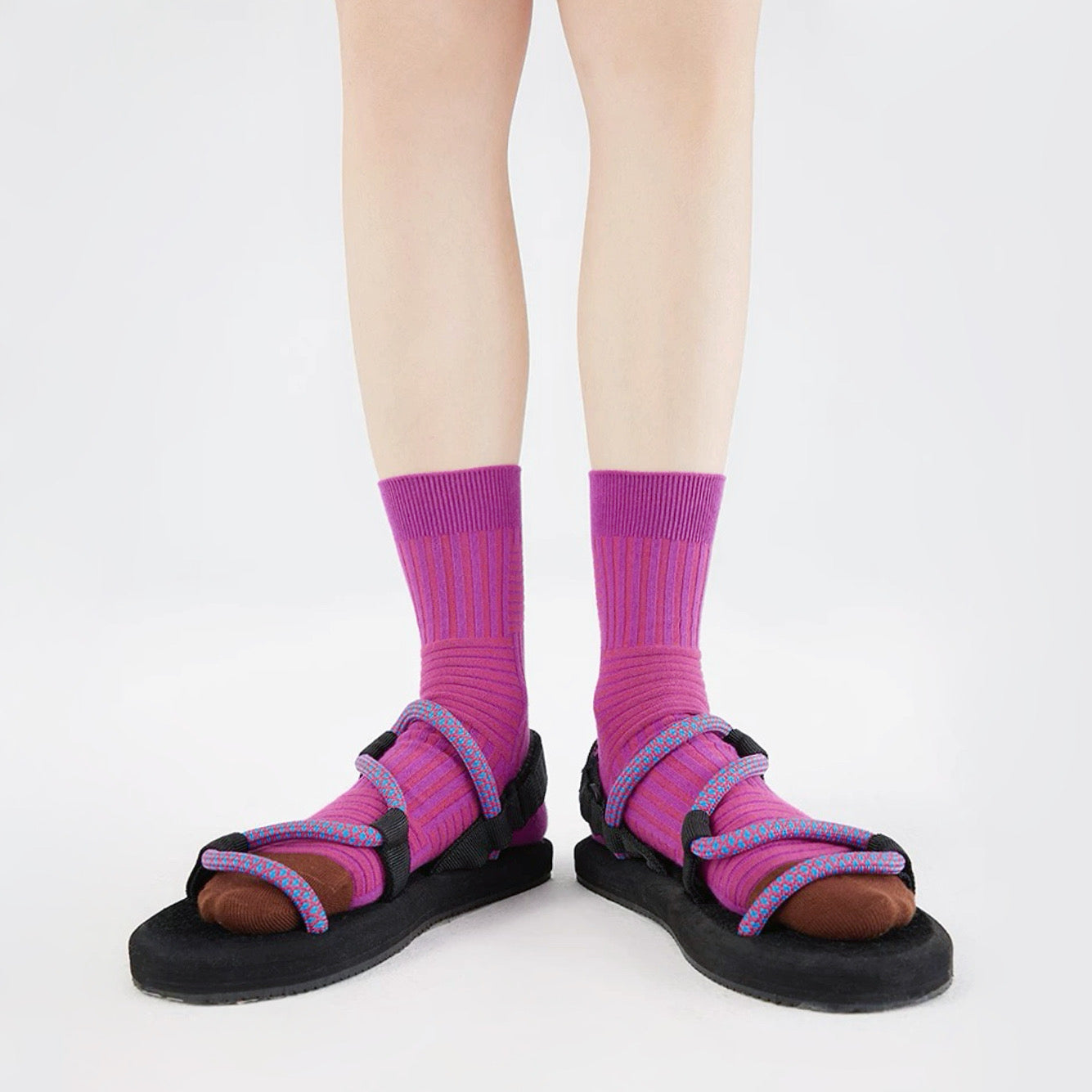 Model wearing a pair of Matrix Stripe Socks in magenta, ideal for workouts and commuting.