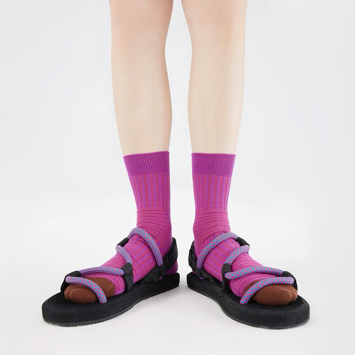 Model wearing a pair of Matrix Stripe Socks in magenta, ideal for workouts and commuting.