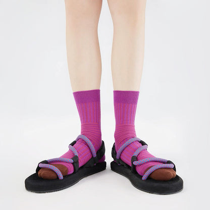 Model wearing a pair of Matrix Stripe Socks in magenta, ideal for workouts and commuting.