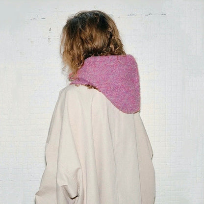 Back view of a mauve pink knitted balaclava hat, showing the seamless hood design and drape.