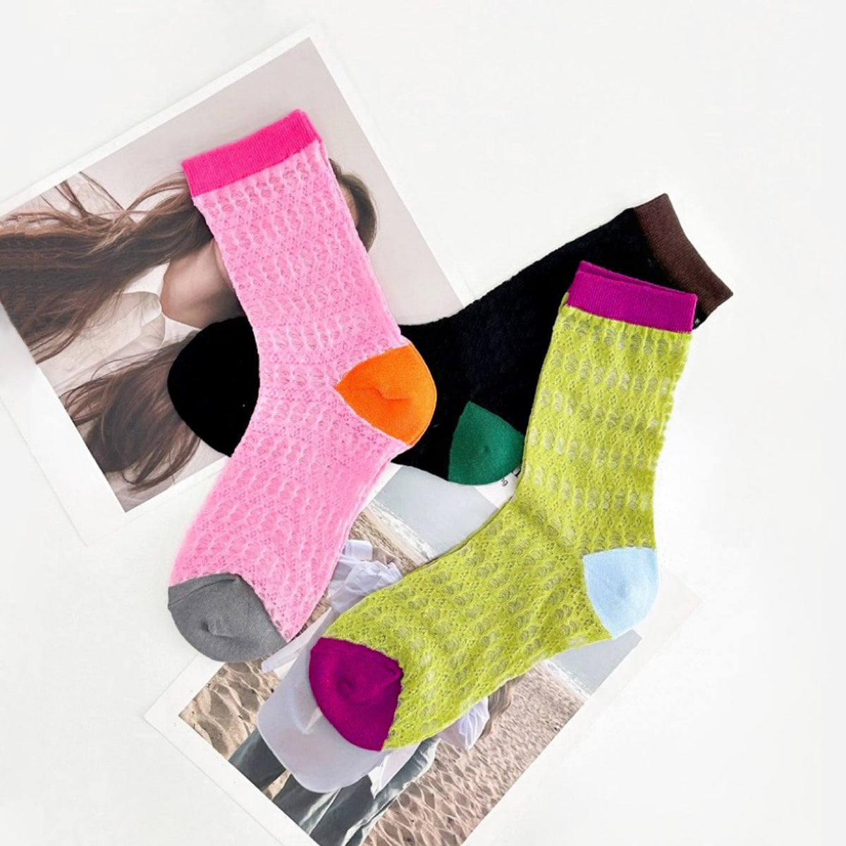 Angled view of Three pairs of colorful mesh gauze socks: pink with orange heel, black with green heel, and lime green.