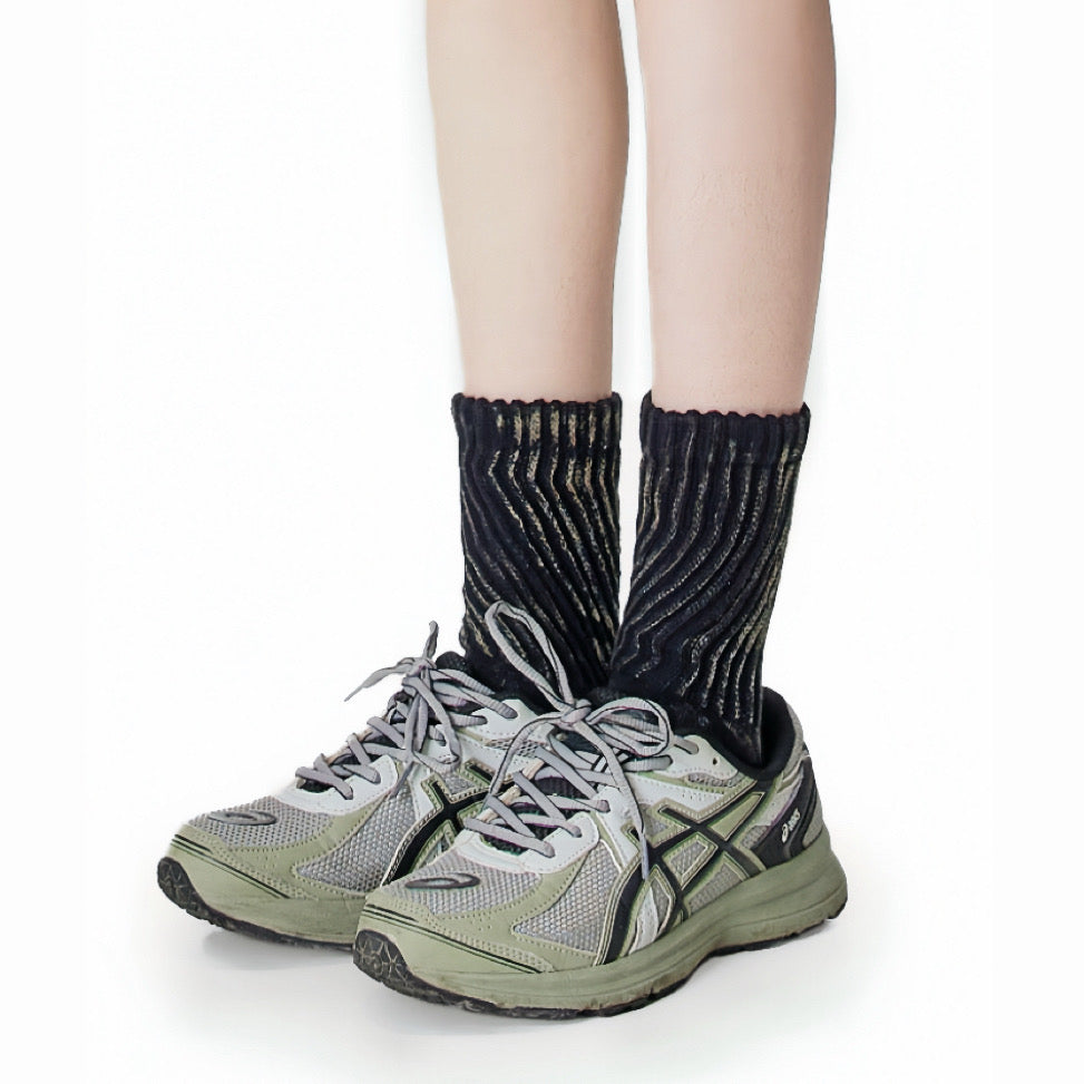 Model wearing a pair of  Metallic Tie Dye Slouch Socks in black, easy to pack for travel and errands.