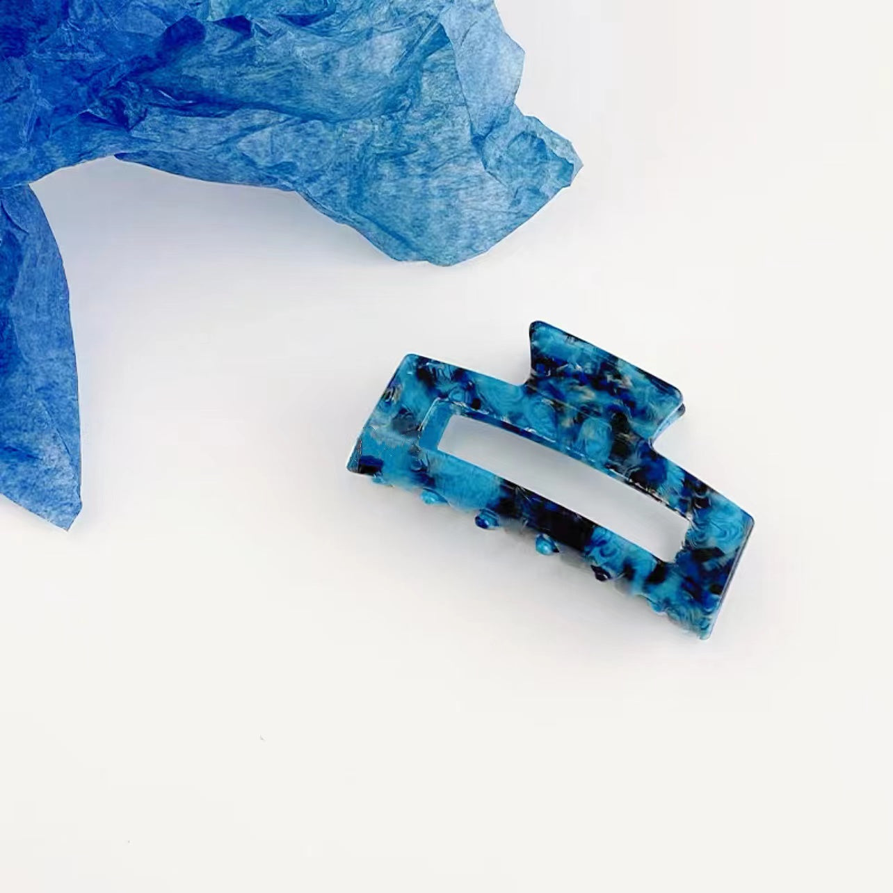 Angled view of blue Midnight Ice Hair Claw in rectangle shape.