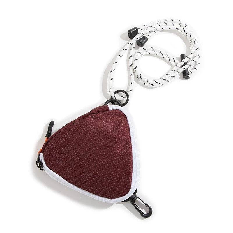 A burgundy triangle mini bag made of durable nylon, featuring a zip-top and adjustable strap.