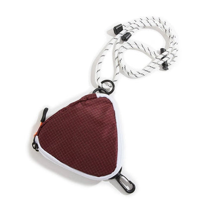 A burgundy triangle mini bag made of durable nylon, featuring a zip-top and adjustable strap.