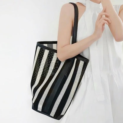 Model carrying the large size black and white striped mesh tote bag over the shoulder.