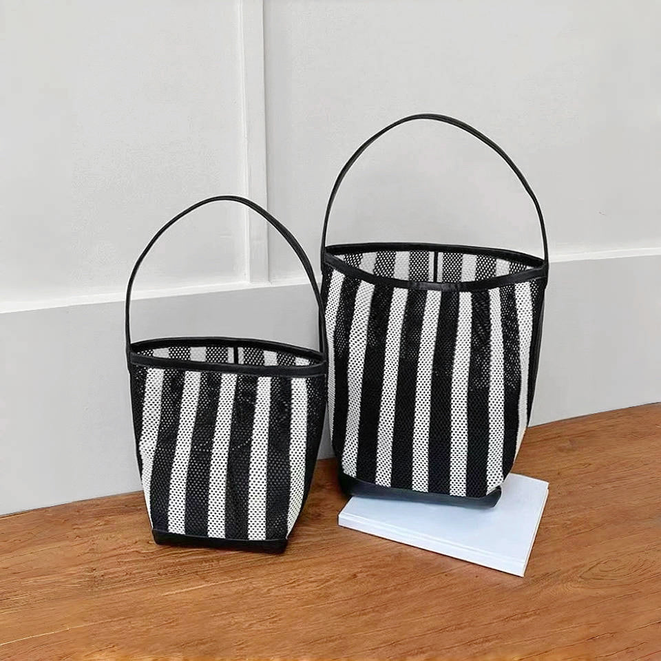 Studio comparison display showing both Large and Small size variations of the monochrome striped mesh beach totes sitting side by side.