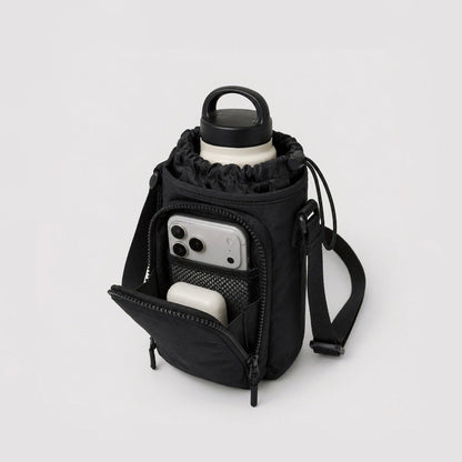 Close-up view of the open front zipper pocket showing an internal smartphone sliding into the separate storage slot.