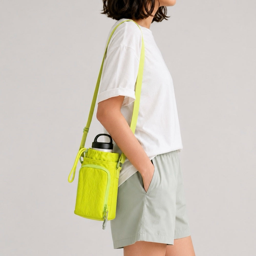 Side profile view of a model carrying the lime green water bottle pouch with its adjustable shoulder strap extended.