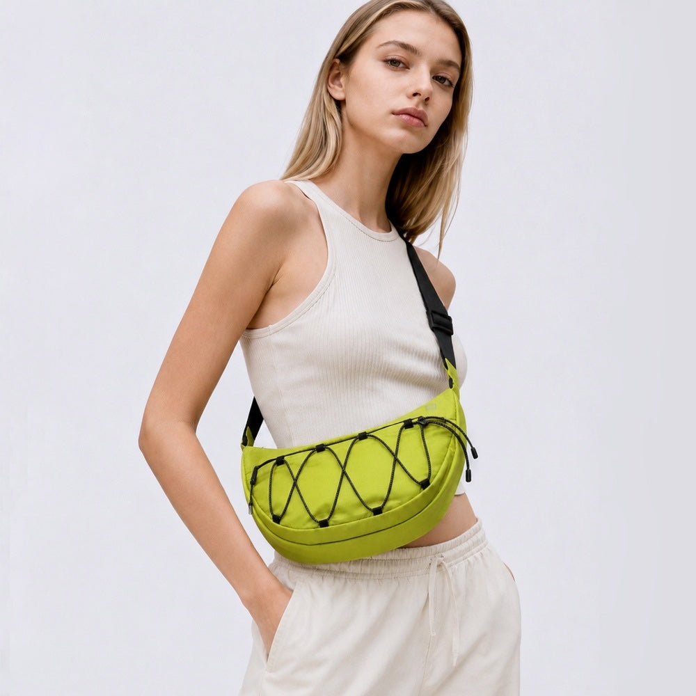 Model wearing a mustard lightweight nylon crescent sling bag as crossbody, showcasing the effortless urban style.