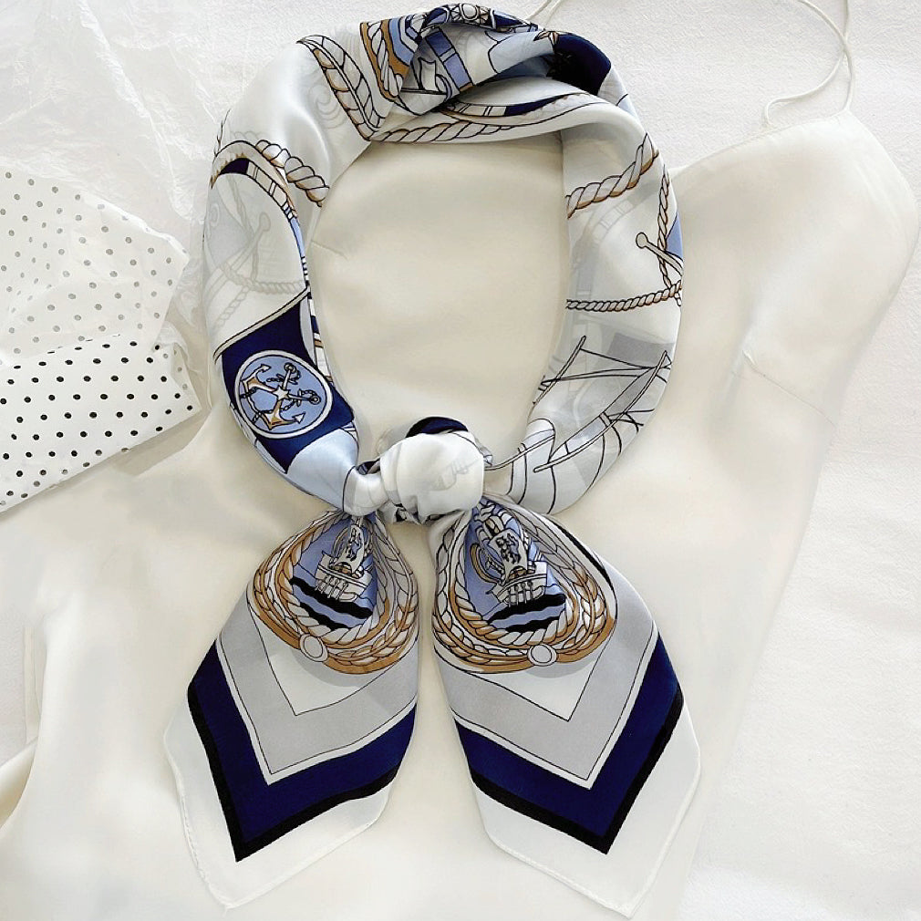 Front view of a tied satin scarf in navy,  elegant accessory styling for handbags.
