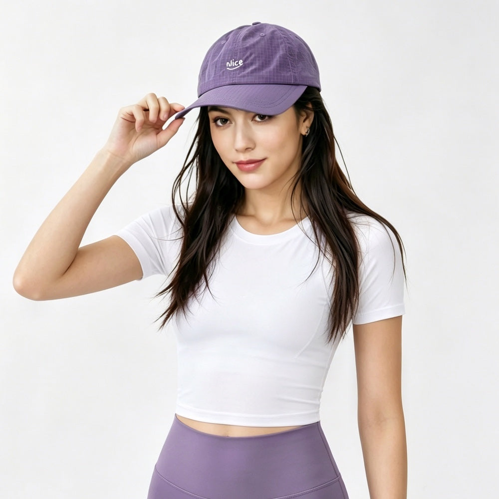 Model styling the purple quick dry running cap to add a pop of color to a gorpcore outfit