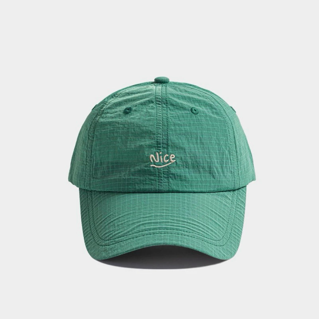 Front flat view of the dark green polyester quick dry cap with minimal text embroidery detail.