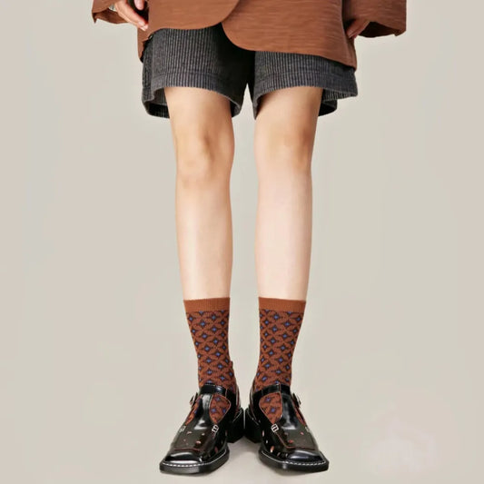 Model wearing a pair of brown socks with a blue diamond pattern.