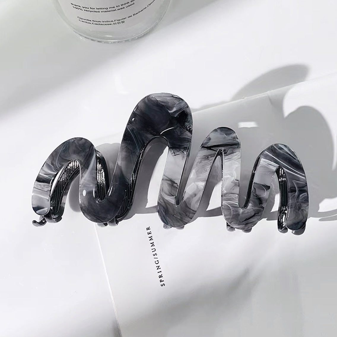 Folded view of Painted Wave Hair Clawn in black, ideal for quick updos and ponytails.
