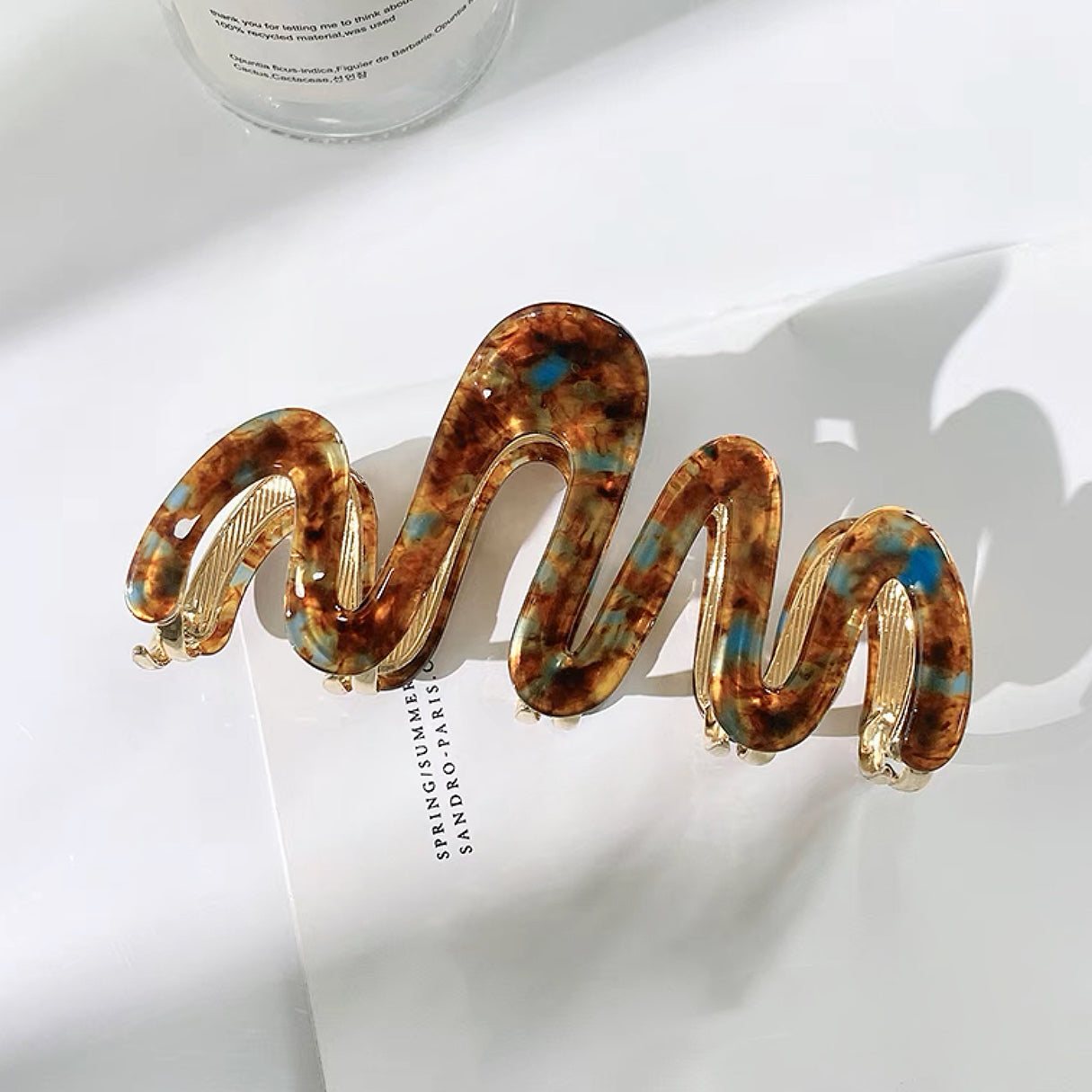 Angled view of Painted Wave Hair Claw  in brown, ideal for quick updos and ponytails.