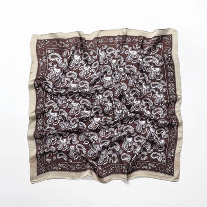 Close-up of brown paisley scarf highlighting refined edge detailing and artistic craftsmanship.