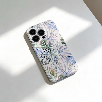 Pastel jungle phone case on a white table, showing it's abstract tropical leaves and geometric patterns.