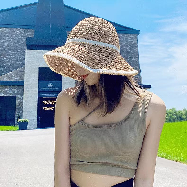Model wearing breathable straw sun hat with pearl accent providing stylish shade for poolside relaxation and picnics.