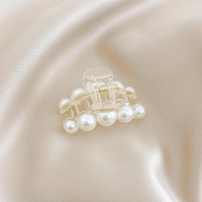 Close-up of a horizontal pearl hair clip; showing the high-tension grip and embedded pearl design.