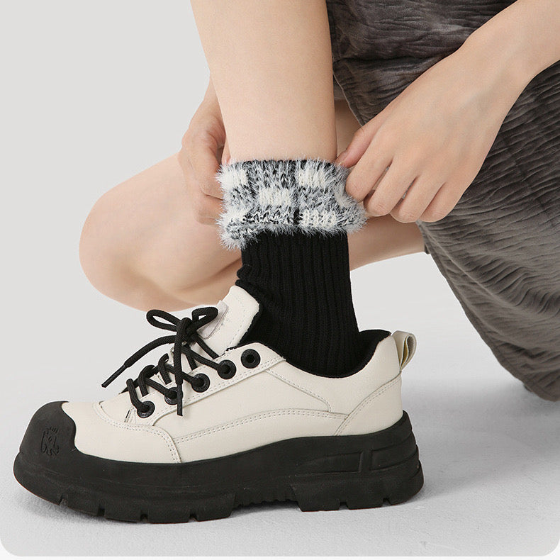 Model wearing a pair of  Plaid Fuzzy Socks in black, great for daily wear and lounging.