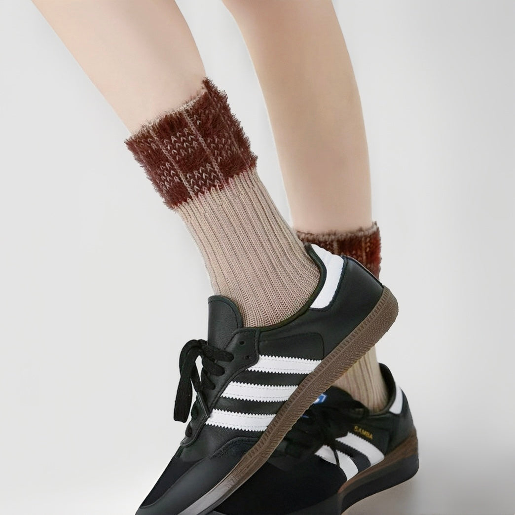 Model wearing a pair of Plaid Fuzzy Socks in khaki, easy to pack for travel and errands.