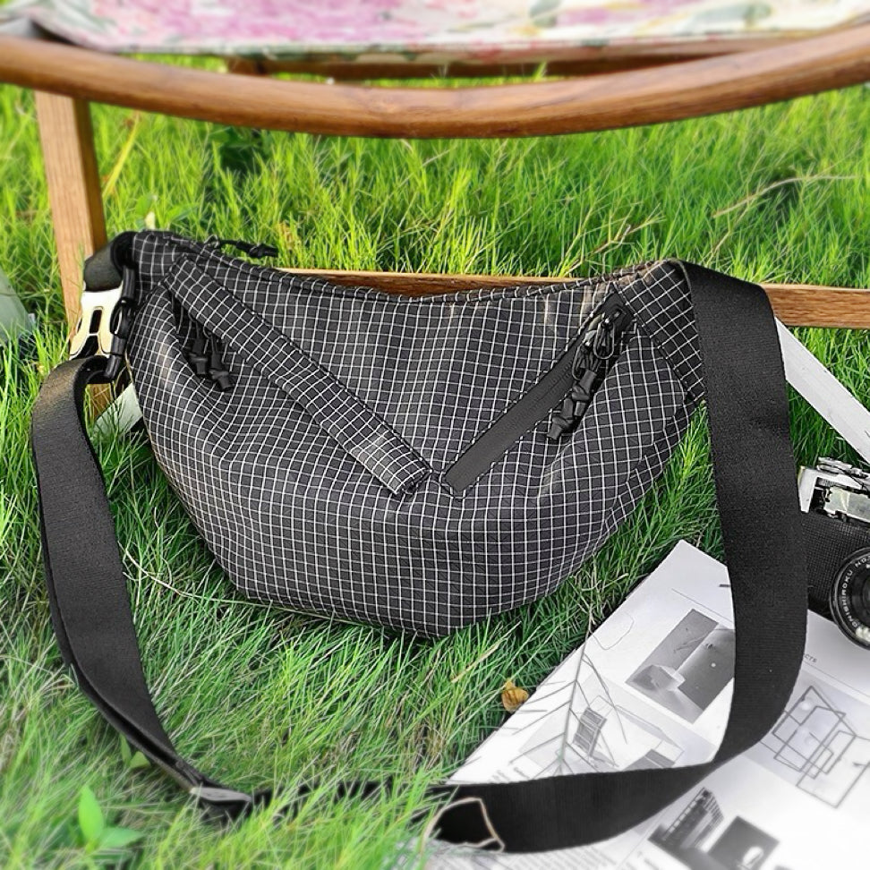 Front view of black plaid nylon sling bag, great for everyday carry and travel.