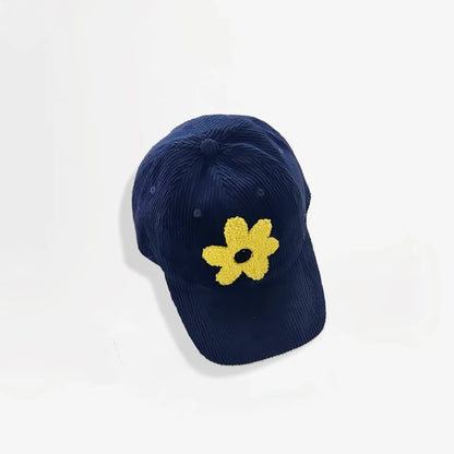 Navy blue corduroy baseball cap featuring a yellow plush flower embroidery.