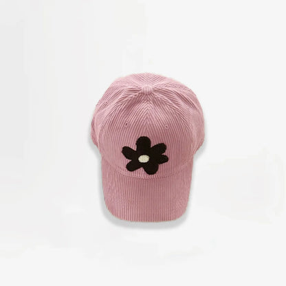 Pink corduroy baseball cap featuring a brown plush flower embroidery.