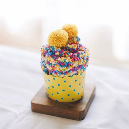 Close-up of Pompom Cupcake Socks in yellow, easy to pack for travel and errands.