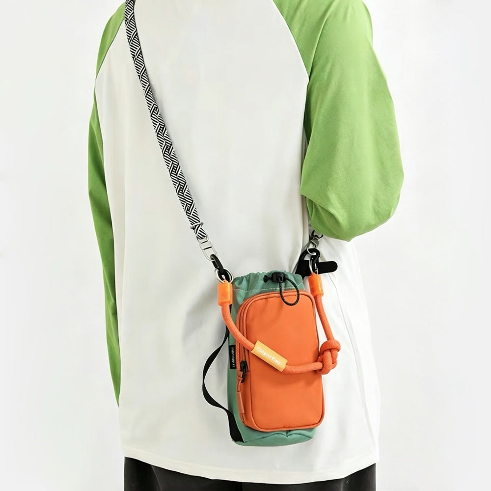Back view of a model wearing a raglan shirt showcasing how the black and white patterned paracord strap of the orange bottle bag sits flat against the shoulder.