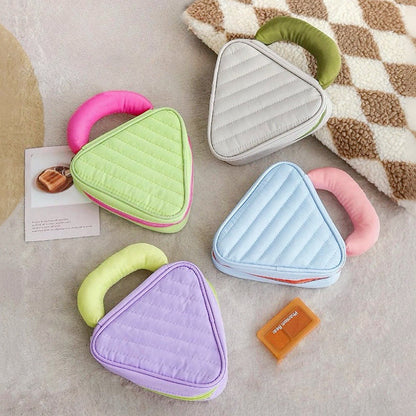 Puffy Candy triangle mini bags in pastel colors; quilted zip cases with curved handle for cute on-the-go storage.