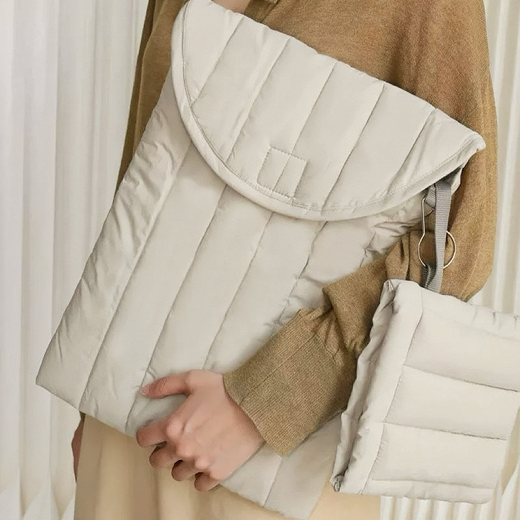 Model holding the light grey puffy laptop sleeve for a clean professional look.