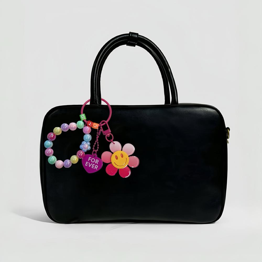 Rainbow Beads Sunflower Bag Charm hanging on a black bag, easy for gifting and photo-ready styling.