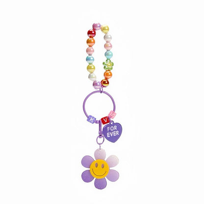Flat lay of Rainbow Beads Sunflower Bag Charm in purple, great for everyday styling and gifting.